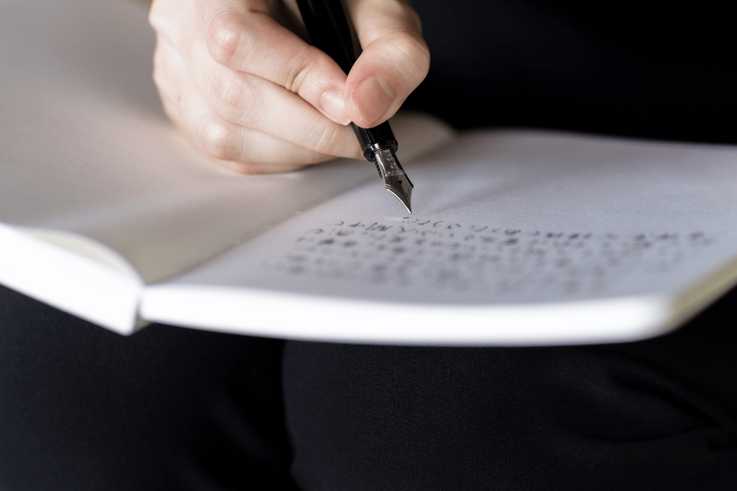 Notebook with fountain pen poised